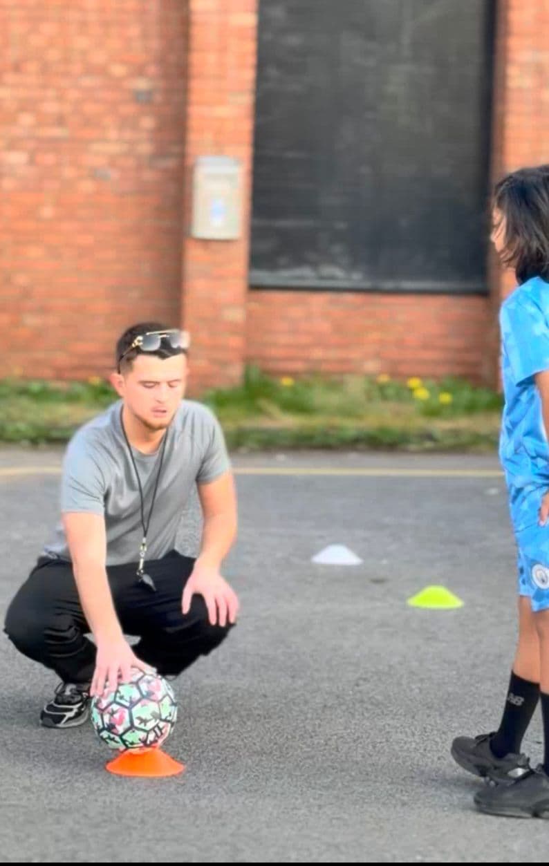 Little Legends coach setting up a football drill with cones